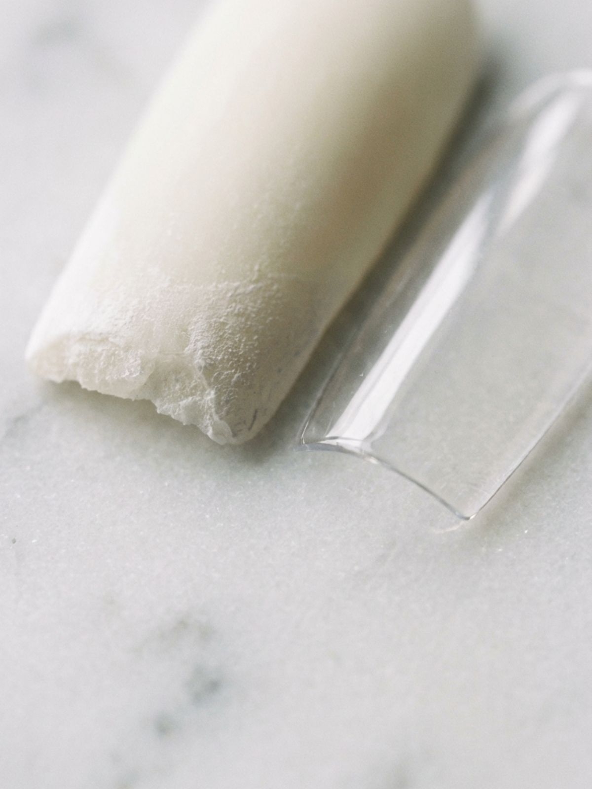 Press-On Nails vs Acrylic Nails - Notice the structural difference: Acrylics (left) offer density, while soft-gel tips (right) provide a thinner, natural edge.